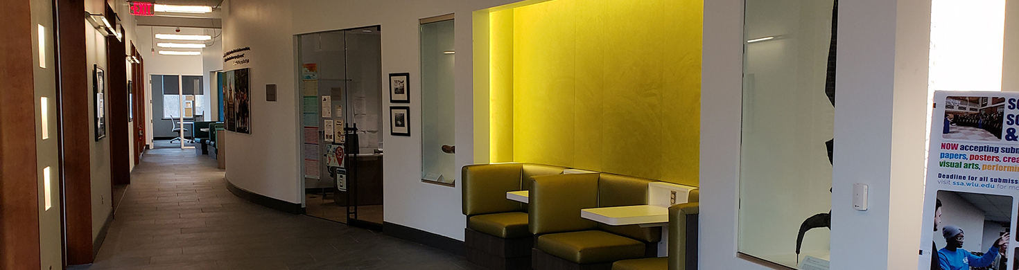 A lit alcove with green-upholstered booth-style seating is visible along a CGL hallway.